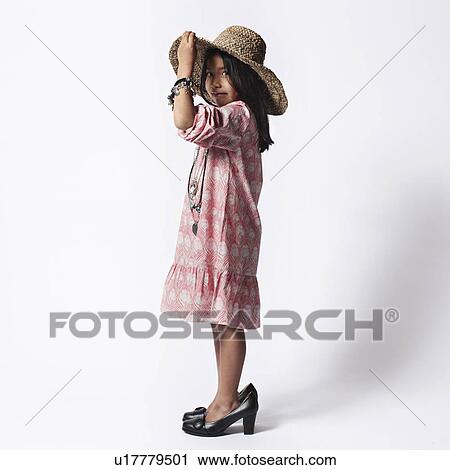 Stock Image - Girl dressing up in mothers shoes . Fotosearch