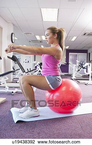 Stock Image - Girl exercising in gym. Fotosearch