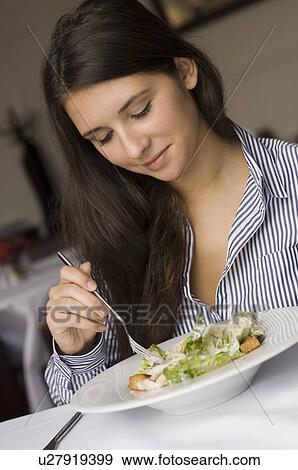 Stock Photo - Girl having plate of food in cafe. Fotosearch