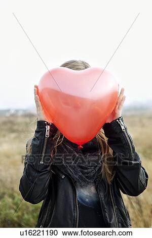 Girl holding heart-shaped balloon View Large Photo Image Stock Image - Girl holding heart-shaped balloon. Fotosearch