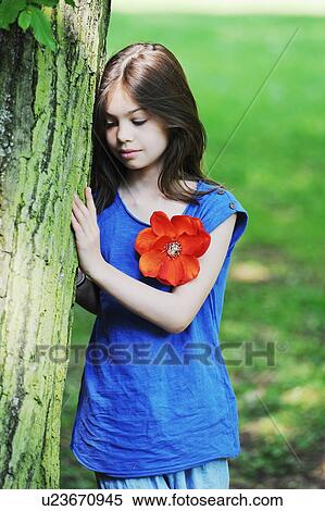 Girl leaning against tree in park View Large Photo Image Stock Photography - Girl leaning against tree in park. Fotosearch
