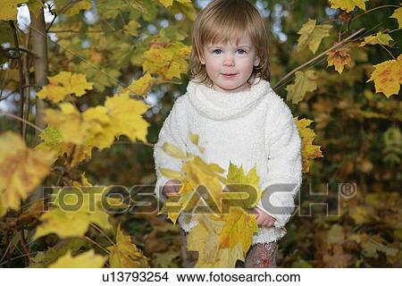 Picture - Girl playing in autumn leaves. Fotosearch