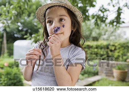 Girl smelling flower outdoors View Large Photo Image Stock Image - Girl smelling flower outdoors. Fotosearch