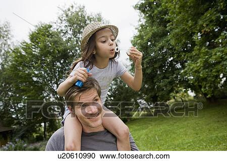 Girl with bubbles on fathers shoulders View Large Photo Image Stock Image - Girl with bubbles on fathers shoulders. Fotosearch