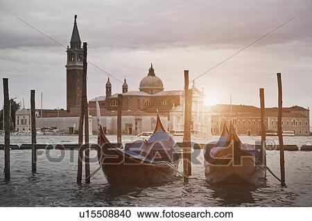 Stock Image - Gondolas docked on urban canal. Fotosearch