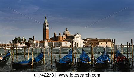 Stock Image - Gondolas docked on urban pier. Fotosearch