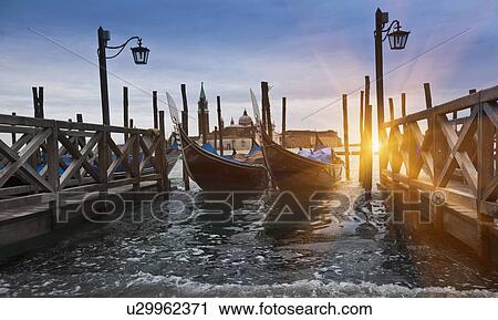 Gondolas docked on urban pier View Large Photo Image Stock Image - Gondolas docked on urban pier. Fotosearch