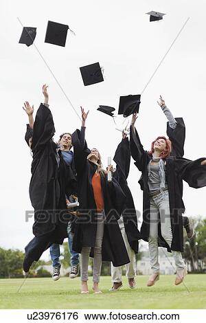 Stock Photograph - Graduates throwing caps in the air. Fotosearch