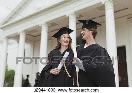 Stock Image - Graduates with their degrees on campus. Fotosearch