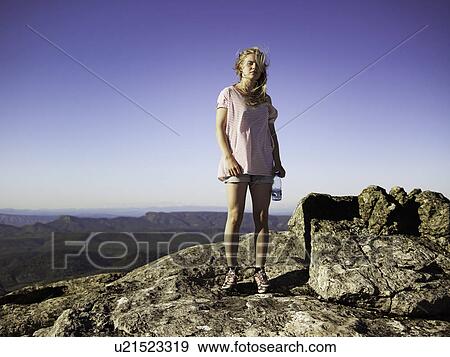 Hiker standing on top of rocky mountain View Large Photo Image Stock Photo - Hiker standing on top of rocky mountain. Fotosearch