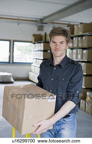 Man carrying cardboard boxes in storage View Large Photo Image Stock Image - Man carrying cardboard boxes in storage. Fotosearch
