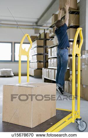 Man filing cardboard boxes in storage View Large Photo Image Stock Image - Man filing cardboard boxes in storage. Fotosearch
