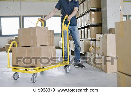 Man filing cardboard boxes in storage View Large Photo Image Stock Photo - Man filing cardboard boxes in storage. Fotosearch