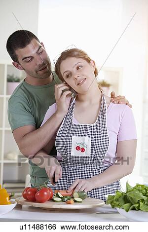 Stock Photograph - Man holding phone for cooking girlfriend. Fotosearch