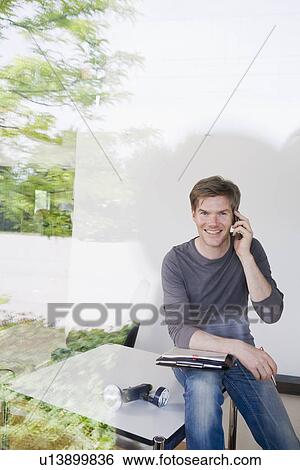 Stock Photograph - Man on cell phone taking notes. Fotosearch