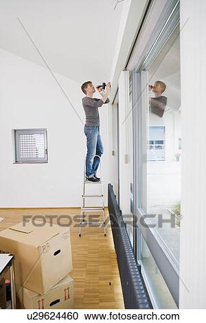 Man painting room in new house View Large Photo Image Stock Image - Man painting room in new house. Fotosearch