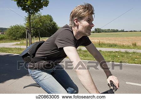 Man riding bicycle on rural road View Large Photo Image Stock Photography - Man riding bicycle on rural road. Fotosearch