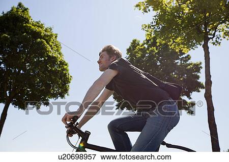 Stock Photo - Man riding bicycle outdoors. Fotosearch