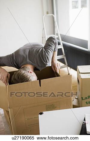 Stock Photography - Man searching cardboard boxes. Fotosearch