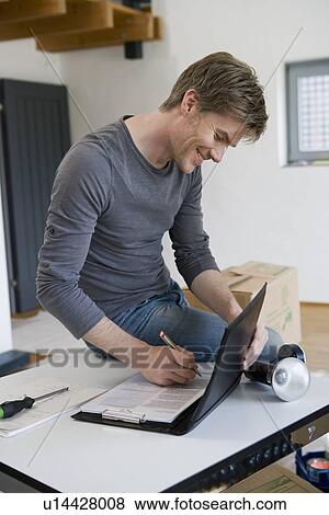 Man working on clipboard and laptop View Large Photo Image Stock Photo - Man working on clipboard and laptop. Fotosearch