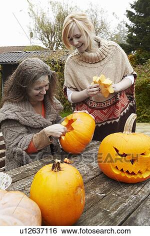 Mother and daughter carving pumpkins View Large Photo Image Stock Photograph - Mother and daughter carving pumpkins. Fotosearch