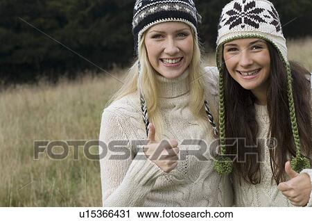 Stock Image - Mother and daughter giving thumbs up. Fotosearch