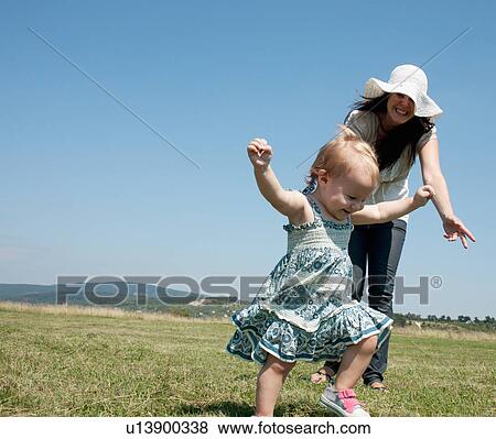 Mother and daughter walking in field View Large Photo Image Stock Photo - Mother and daughter walking in field. Fotosearch