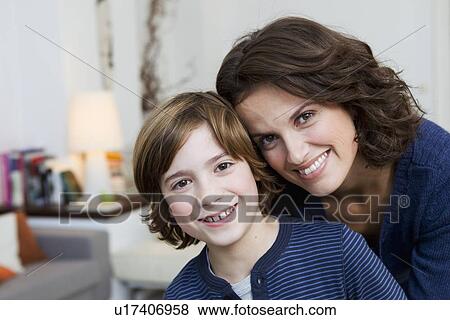Stock Photo - Mother and son hugging in living room. Fotosearch