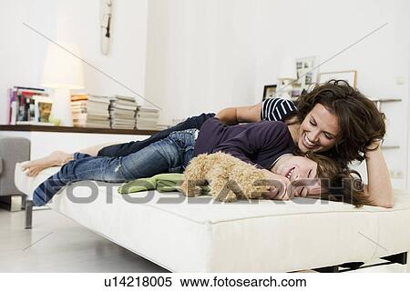 Stock Photography - Mother and son relaxing in living room. Fotosearch