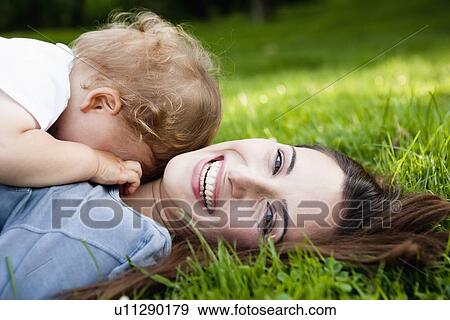 Stock Photo - Mother holding toddler in park. Fotosearch