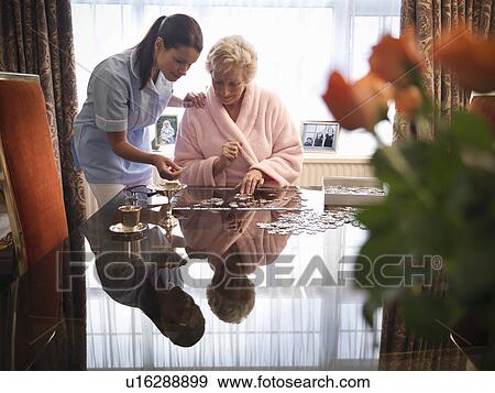 Nurse and older woman with jigsaw puzzle View Large Photo Image Stock Photo - Nurse and older woman with jigsaw puzzle. Fotosearch