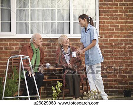 Stock Photo - Nurse bringing older couple coffee. Fotosearch