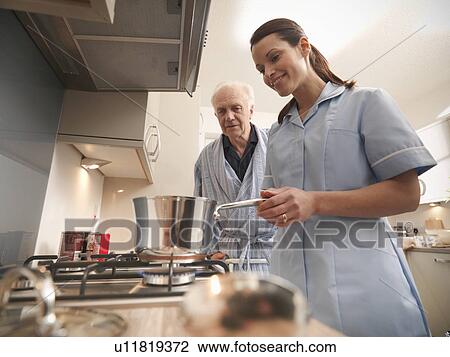 Nurse cooking for older man in kitchen View Large Photo Image Stock Image - Nurse cooking for older man in kitchen. Fotosearch