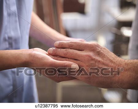 Stock Photography - Nurse examining older mans hands. Fotosearch