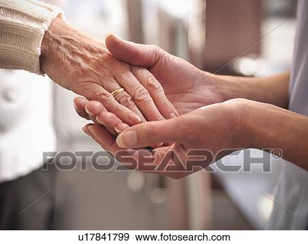 Stock Photo - Nurse holding older mans hand. Fotosearch