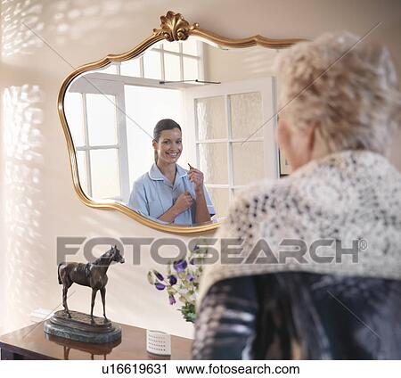 Nurse looking at older woman in mirror View Large Photo Image Stock Image - Nurse looking at older woman in mirror. Fotosearch