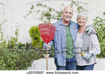 Stock Photo - Older couple gardening in backyard. Fotosearch