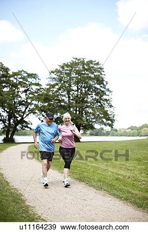 Stock Photo - Older couple jogging together outdoors. Fotosearch