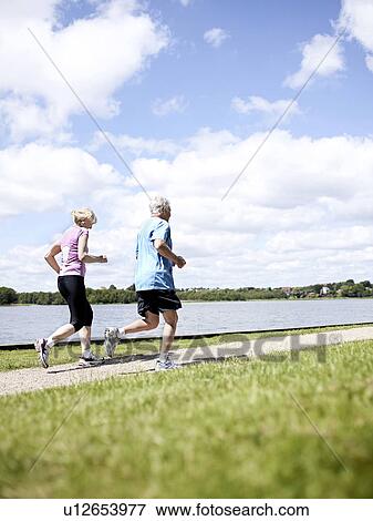 Older couple jogging together outdoors View Large Photo Image Stock Photo - Older couple jogging together outdoors. Fotosearch