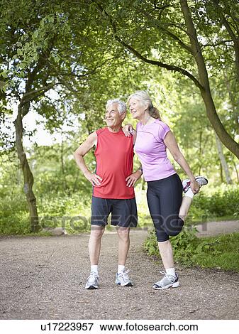 Older couple stretching in park View Large Photo Image Stock Photo - Older couple stretching in park. Fotosearch