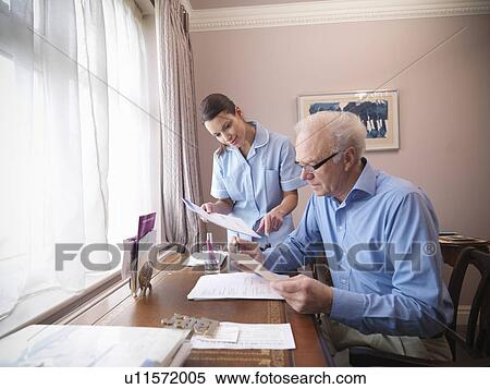 Stock Photography - Older man and nurse reading papers. Fotosearch