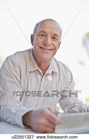 Older man reading newspaper outdoors View Large Photo Image Stock Photo - Older man reading newspaper outdoors. Fotosearch