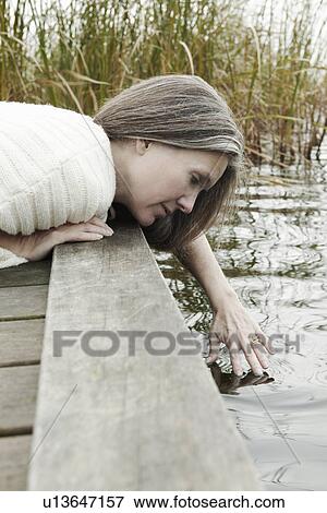 Older woman dipping fingers into lake View Large Photo Image Stock Photo - Older woman dipping fingers into lake. Fotosearch