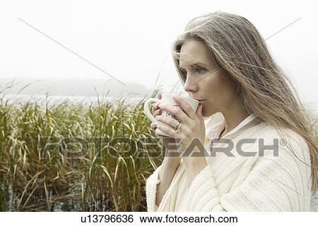 Older woman drinking coffee outdoors View Large Photo Image Stock Photograph - Older woman drinking coffee outdoors. Fotosearch