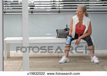 Older woman drinking water in gym View Large Photo Image Stock Image - Older woman drinking water in gym. Fotosearch
