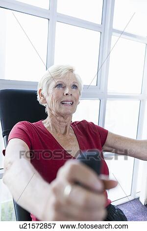 Stock Photo - Older woman exercising in gym. Fotosearch
