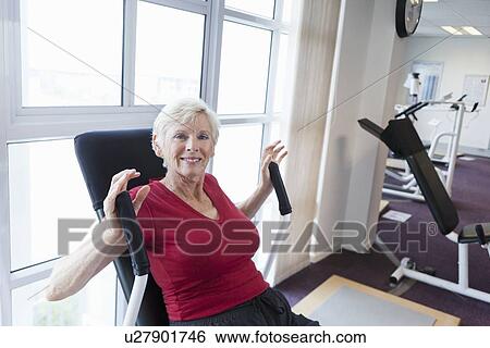 Stock Photograph - Older woman exercising in gym. Fotosearch