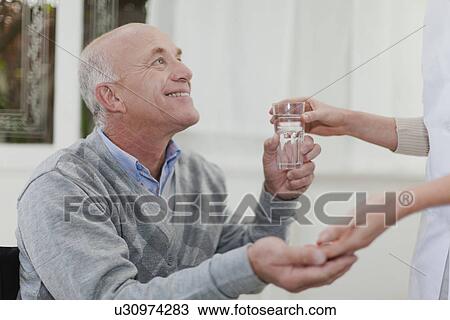 Older woman giving husband medication View Large Photo Image Stock Image - Older woman giving husband medication. Fotosearch