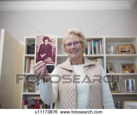 Older woman holding old photograph View Large Photo Image Stock Photograph - Older woman holding old photograph. Fotosearch