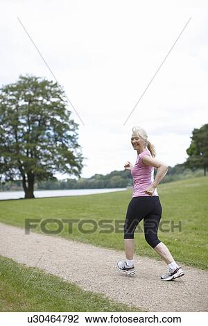 Older woman jogging in park View Large Photo Image Stock Image - Older woman jogging in park. Fotosearch
